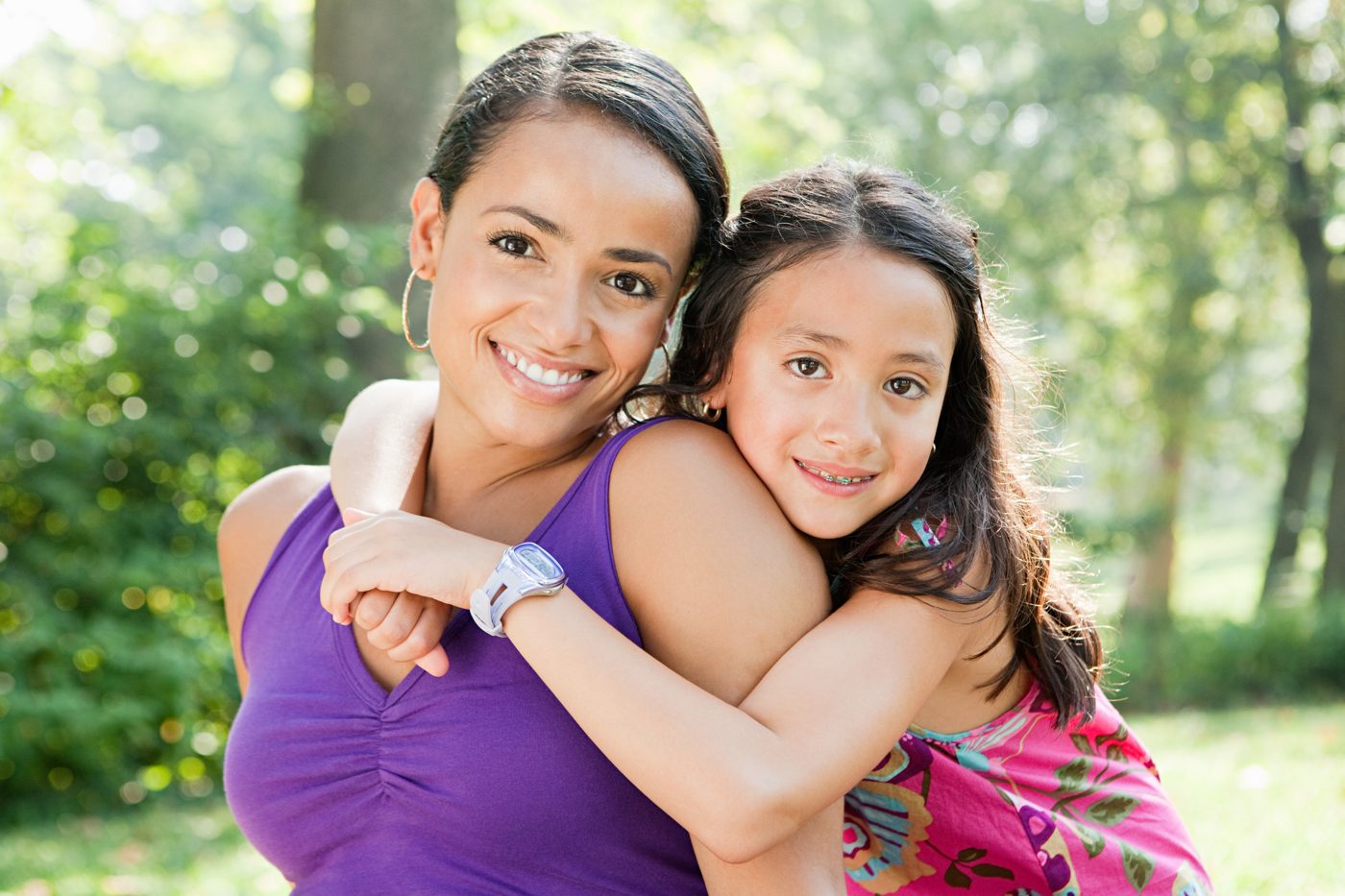 Madre e hija sonriendo al aire libre