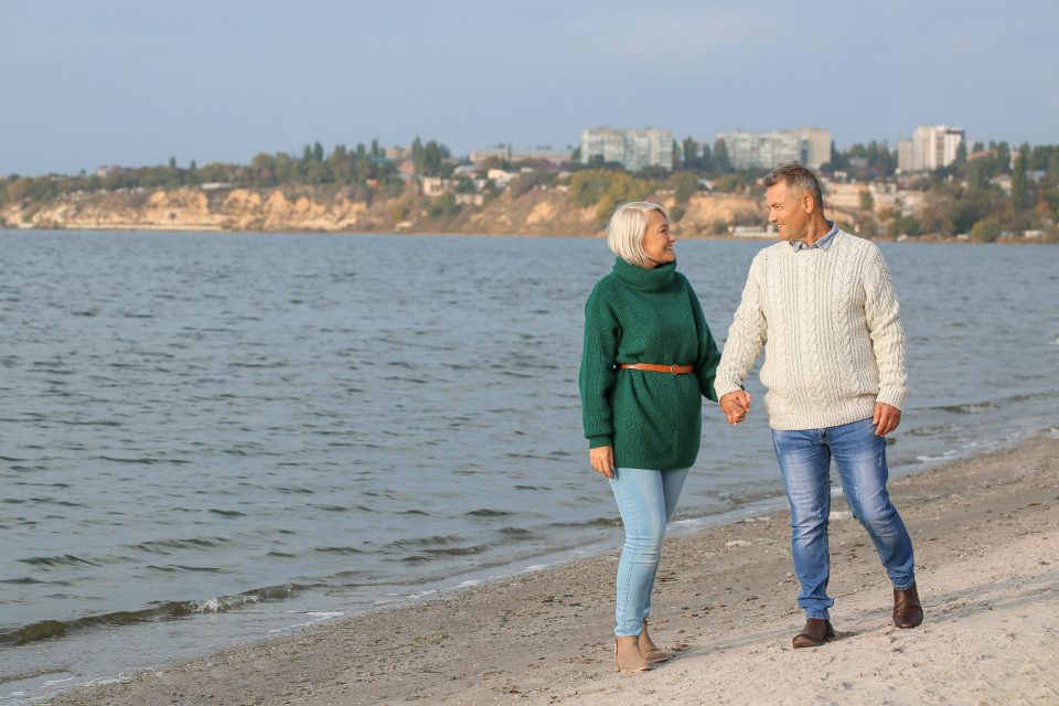 Retired couple walking along the shore